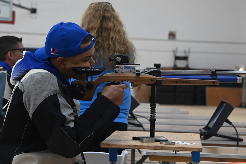 A man aims an air rifle at a target.