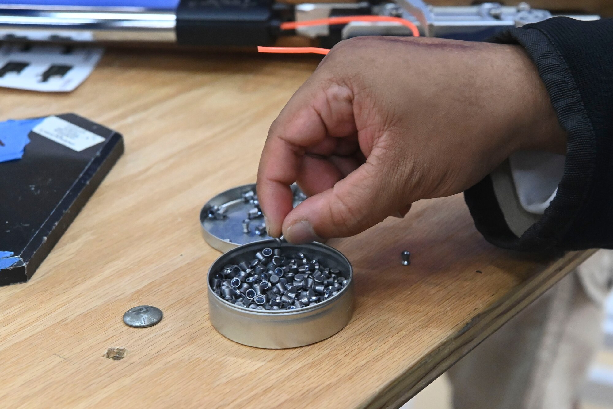 A hand picks pellets out of a container.