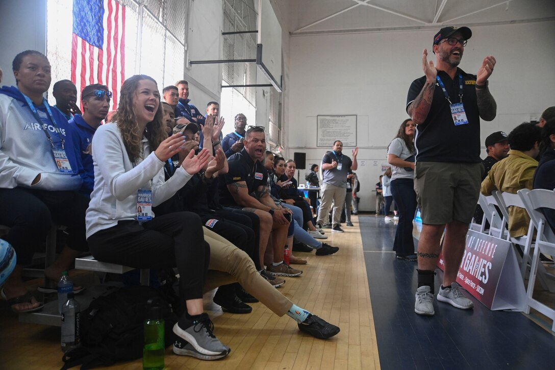 A crowd cheers in a gymnasium.