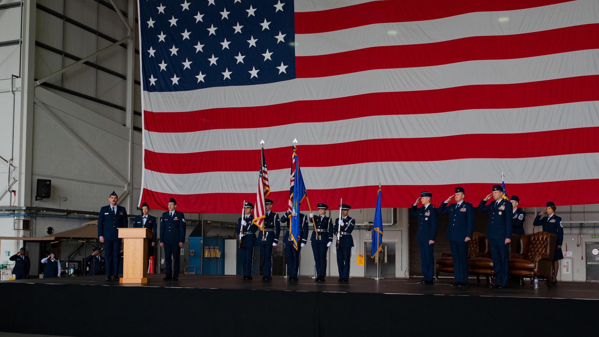 U.S. Air Force Airmen assigned to the 100th Air Refueling Wing salute as the national anthem is sung during the 100th ARW change of command ceremony at Royal Air Force Mildenhall, England, July 17, 2023.