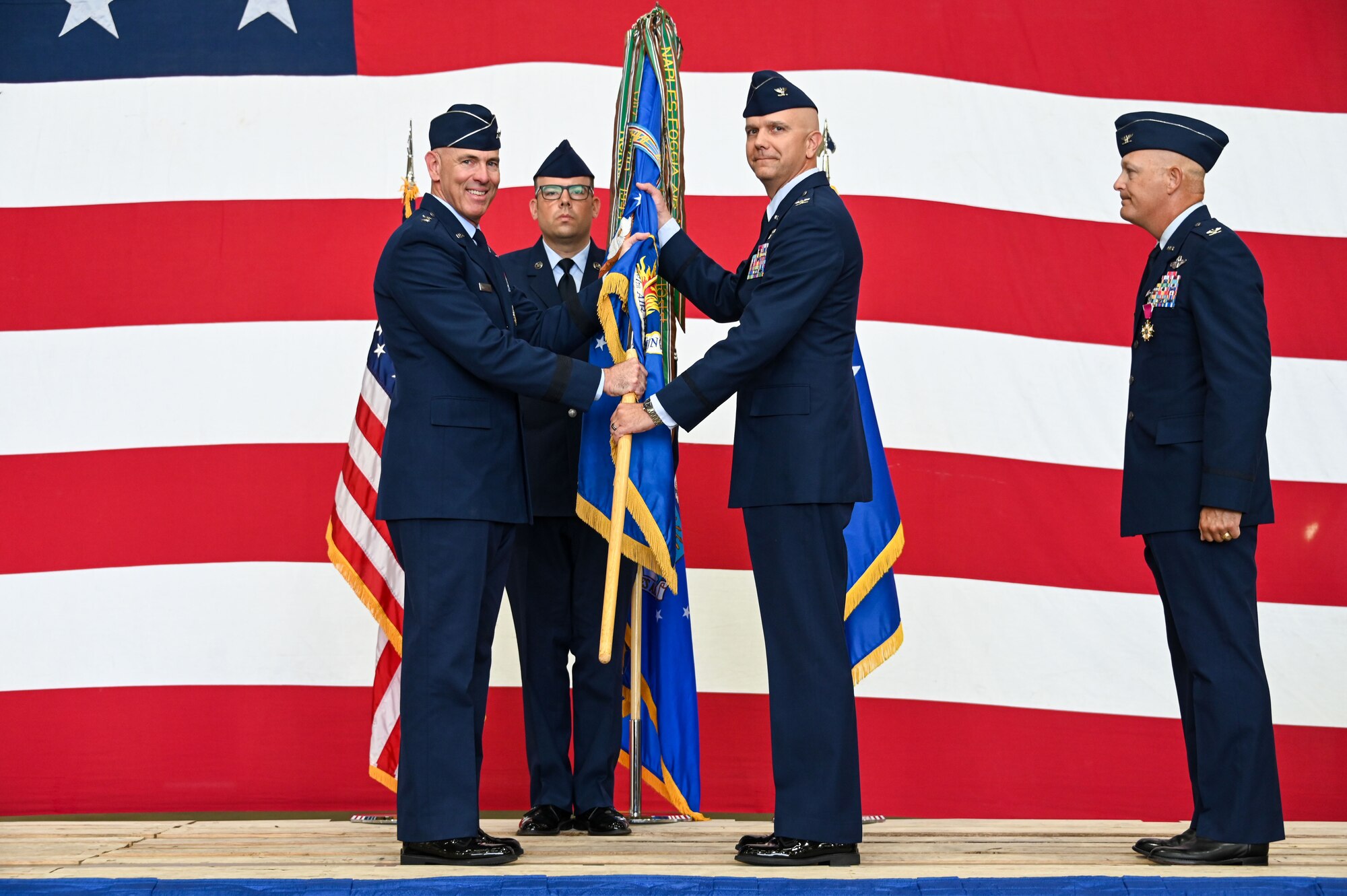 U.S. Air Force Maj. Gen. Clark Quinn, 19th Air Force commander, passes the 97th Air Mobility Wing (AMW) guidon to Col. Jeffrey Marshall, 97th Air Mobility Wing commander, during a change of command ceremony at Altus Air Force Base (AFB),Oklahoma, July 14, 2023. Marshall was previously stationed ay Altus AFB as the Operations Support Squadron commander. (U.S. Air Force photo by Senior Airman Kayla Christenson)