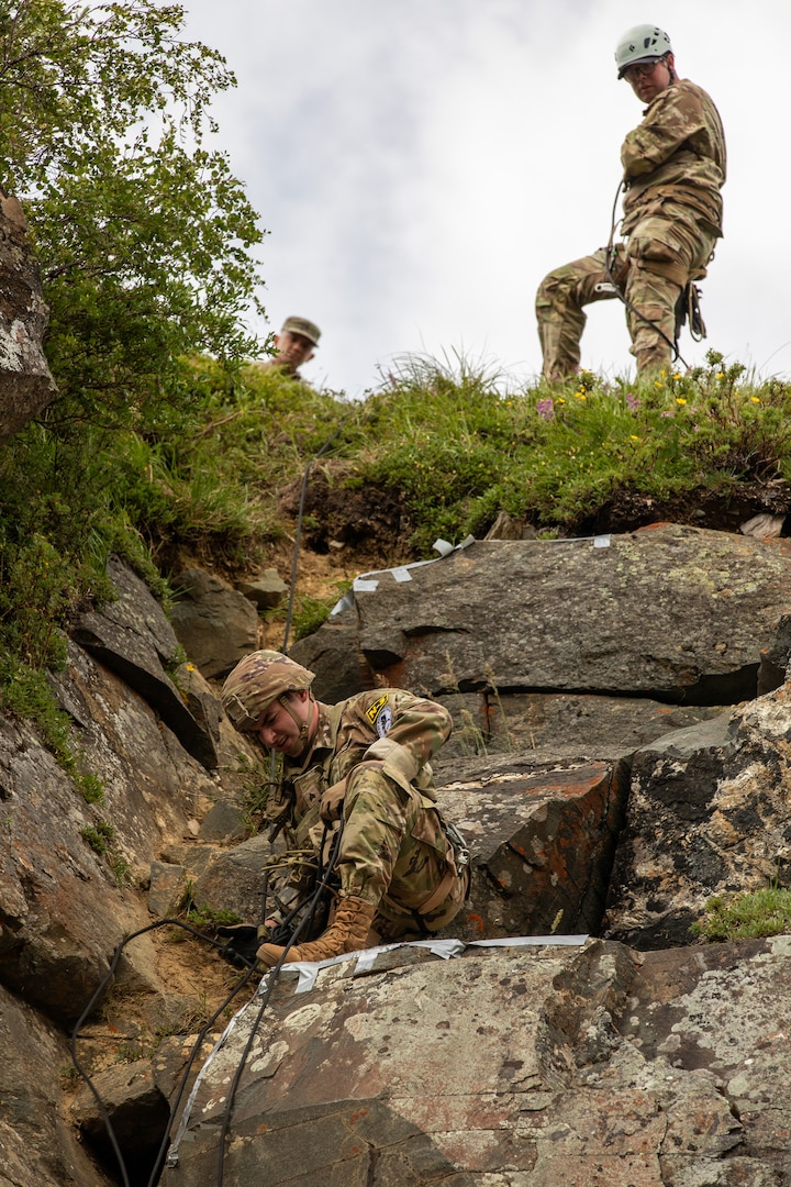 U.S. Army Sgt. Quentin Holden, a UH-60 crew chief assigned to the Georgia Army National Guard, representing Region III, climbs a rock face during the 2023 Army National Guard Best Warrior Competition at Black Rapids Training Area, Alaska on July 10, 2023.
