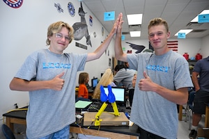 Left, Brady Williams and Thomas Longhurst pose by a project they built attending a LEGACY summer camp during an open house event at Hill Air Force Base, Utah, July 14, 2023. At the event, students showcased to family and friends the projects they worked on during the weeklong camp. The LEGACY program aims to inspire the next generation of science, technology, engineering and math professionals. It is a three-phased program designed for students from 11-years-old to the completion of their bachelor’s degree. (U.S. Air Force photo by R. Nial Bradshaw)