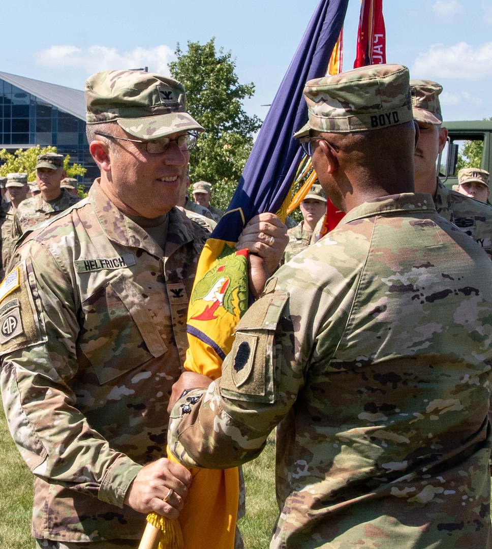 Illinois Army National Guard Col. David Helfrich, of Smithton, Illinois, incoming commander of the 404th Maneuver Enhancement Brigade (MEB) receives the brigade’s colors from Maj. Gen. Rodney Boyd, of Naperville, Illinois, Assistant Adjutant General – Army and Commander of the Illinois Army National Guard, during the change of command ceremony July 14 at the brigade’s headquarters on the campus of Heartland Community College in Normal, Illinois.