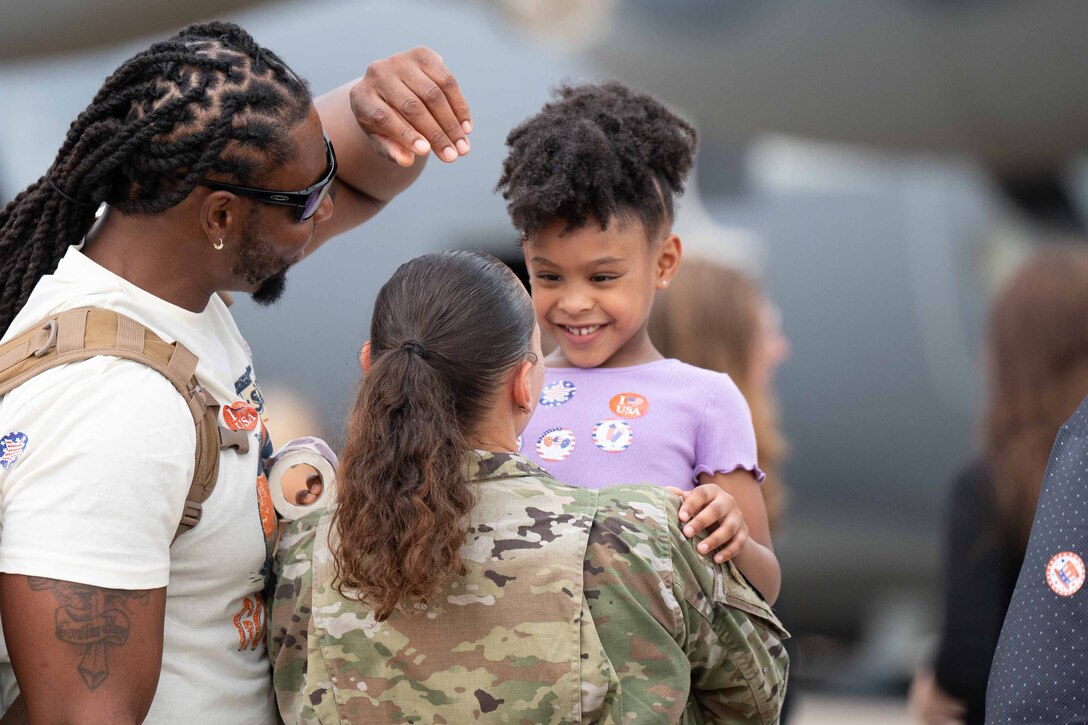 An airman holds a smiling child.
