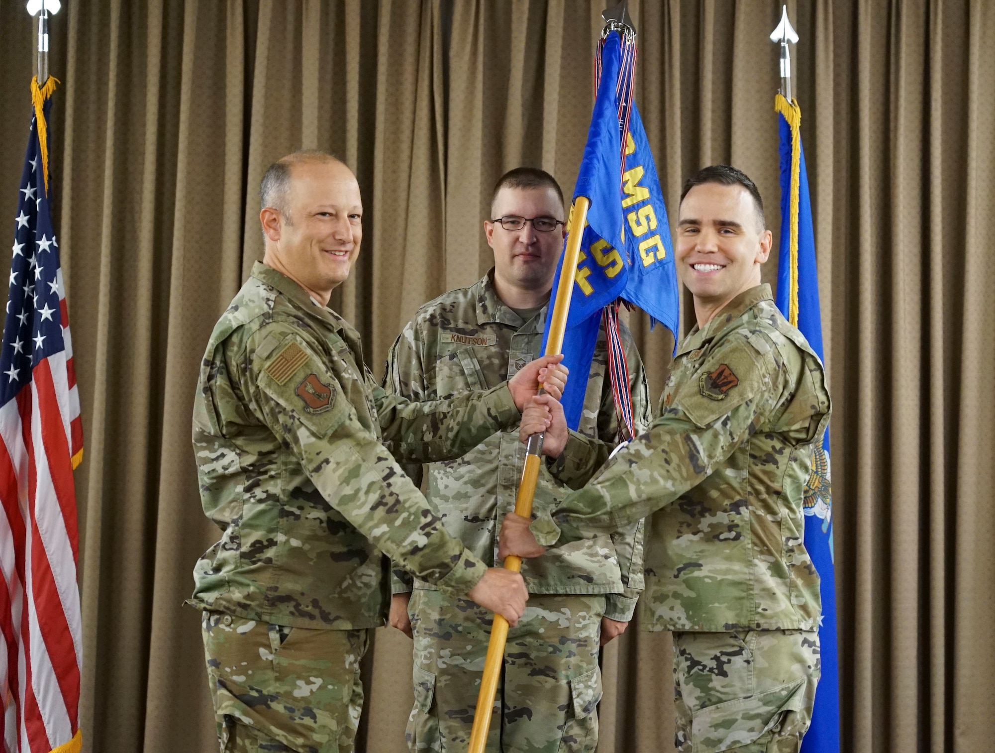 U.S. Air Force Col. David Castor passes the 319th FSS guidon to U.S.  Air Force Maj. Andrew Beidler.