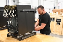 In this link preview image, a person wearing a black shirt works on a processing rack in a work area.