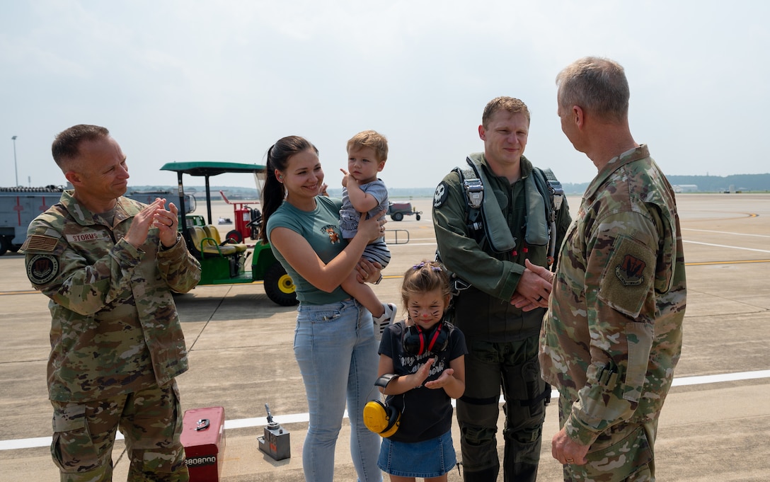 Senior Airman Kostiantyn Khymchenko is surpirsed on the flightline by his family, friends, coworkers, the COMACC and the command chief of ACC