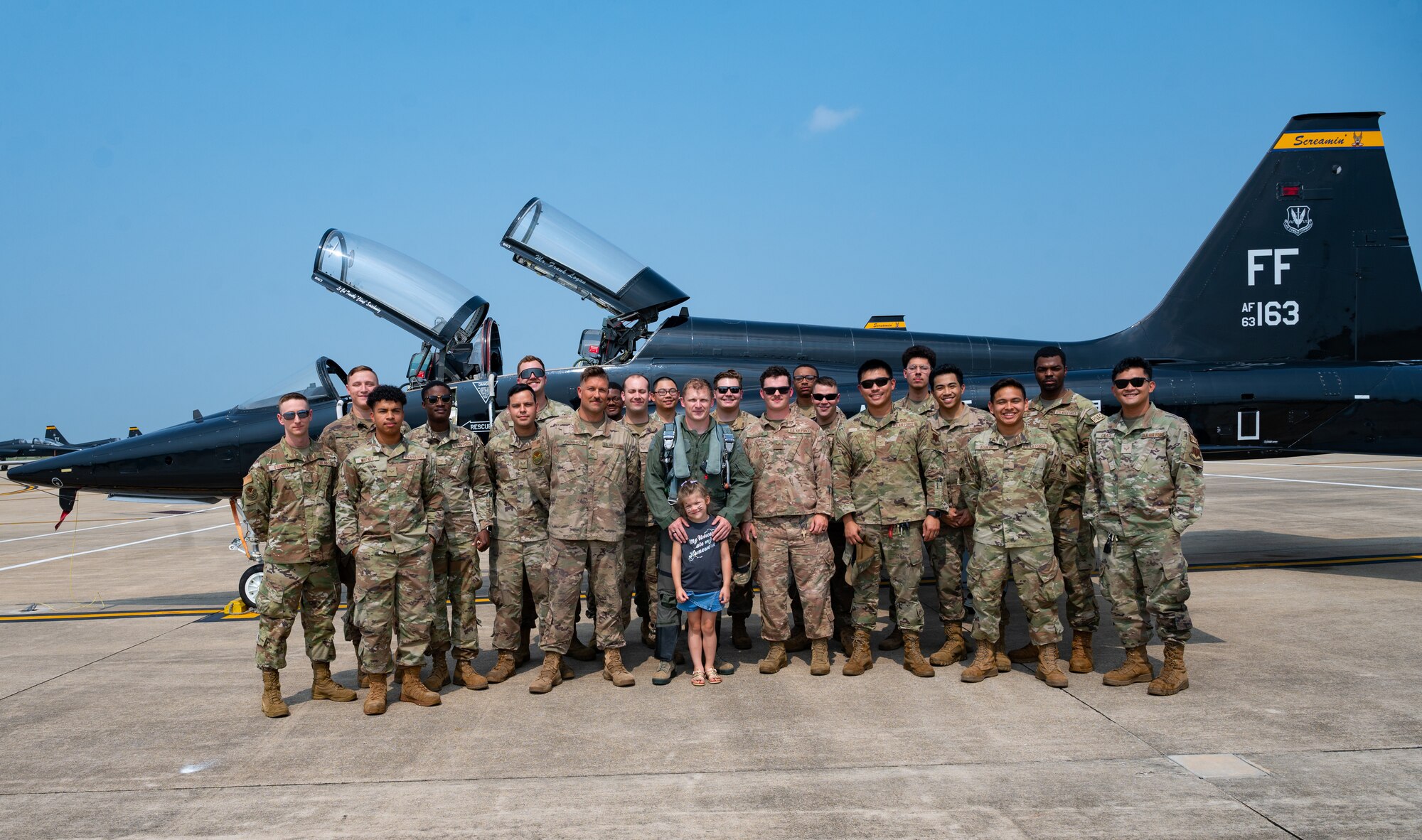 Senior Airman Kostiantyn Khymchenko is surpirsed on the flightline by his family, friends, coworkers, the COMACC and the command chief of ACC