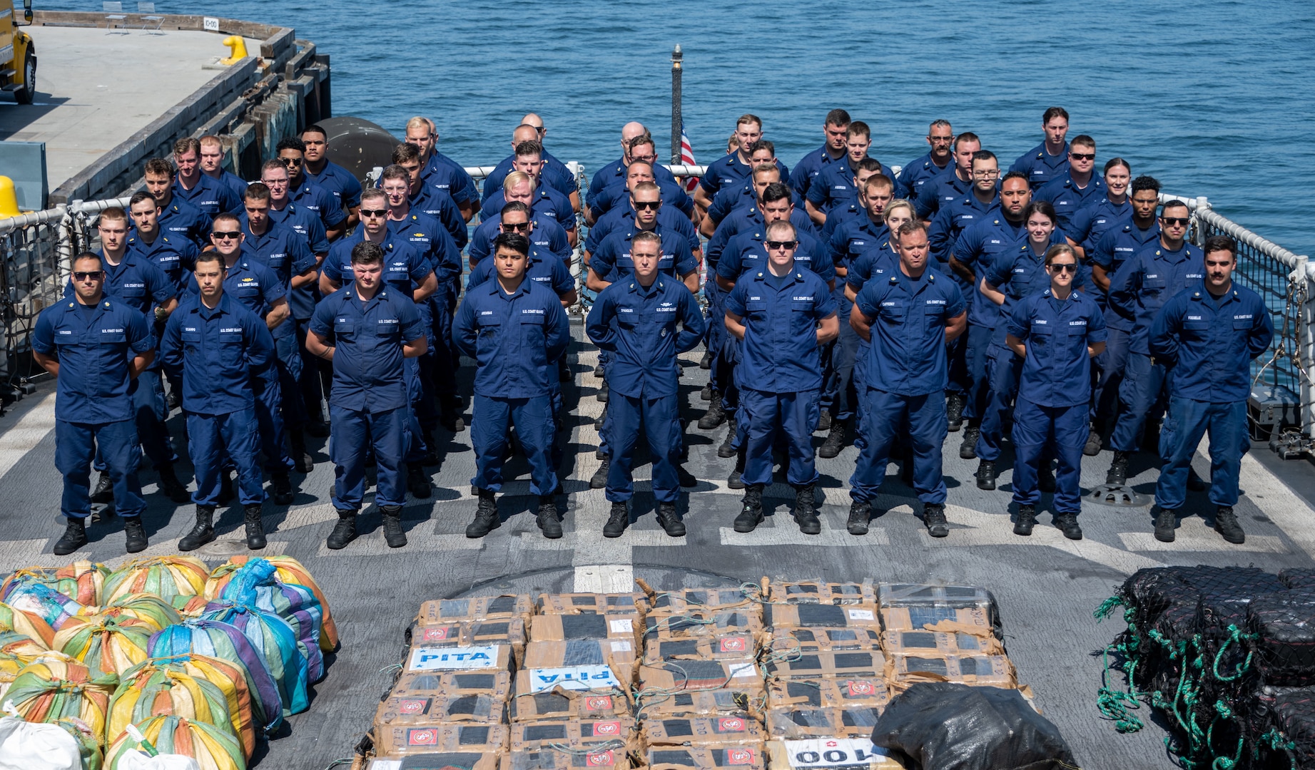 Coast Guard members stand at attention on the deck of the cutter.