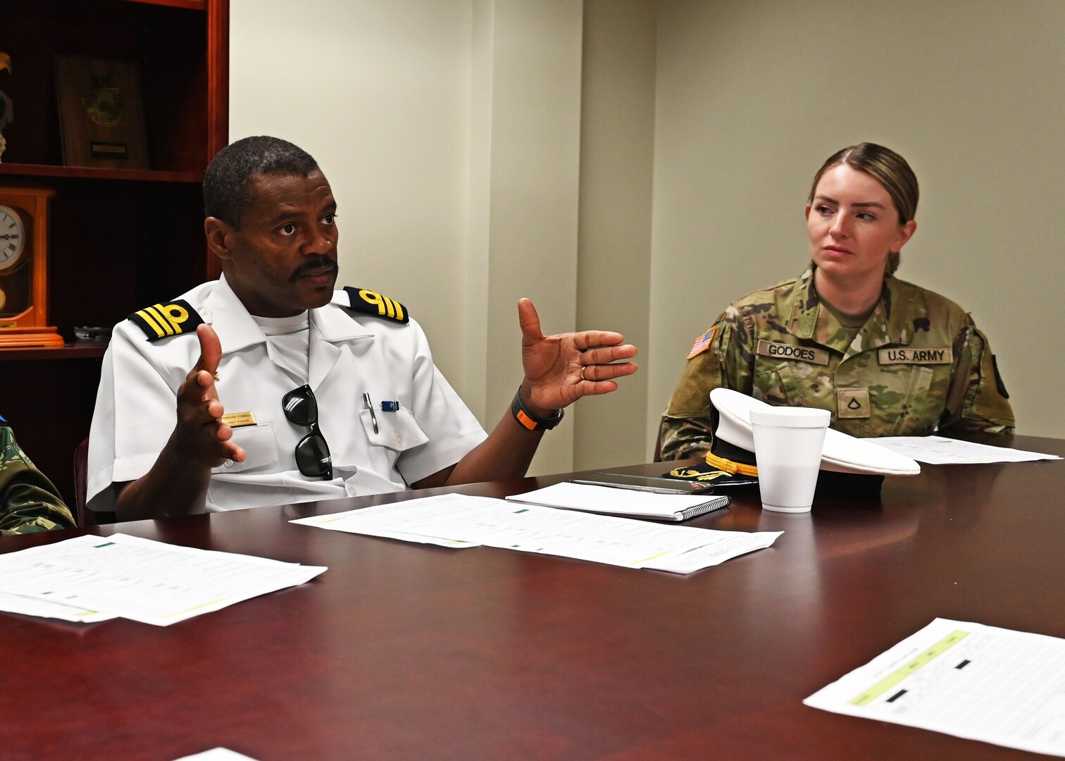 From left, Lt. Col. Domingos Correia, national director of defense for Cabo Verde, and Pfc. Stefane Godoes de Souza, an interpreter with the 197th Field Artillery Brigade, meet with NHARNG aviators during a state partnership exchange July 11, 2023, at the Army Aviation Support Facility in Concord, New Hampshire.
