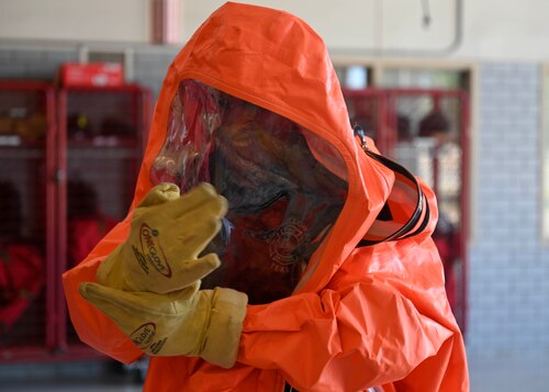 Justin Nava, 17th Civil Engineer Squadron firefighter, demonstrates how to put on a hazmat suit before beginning the hazmat training course during Junior Firefighter Camp at the fire station, Goodfellow Air Force Base, Texas, July 12, 2023. Hazmat suits are designed to withstand various chemical, biological, and radioactive substances so individuals are adequately protected. (U.S. Air Force photo by Airman 1st Class Madison Collier)