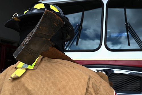 Justin Nava, 17th Civil Engineer Squadron firefighter, carries his gear at the fire station, Goodfellow Air Force Base, Texas, June 30, 2023. A flat-head fire axe is a versatile tool which can be used for smashing windows and doors to create an entry access point or can chop holes in a roof to create ventilation. (U.S. Air Force photo by Airman 1st Class Madison Collier)