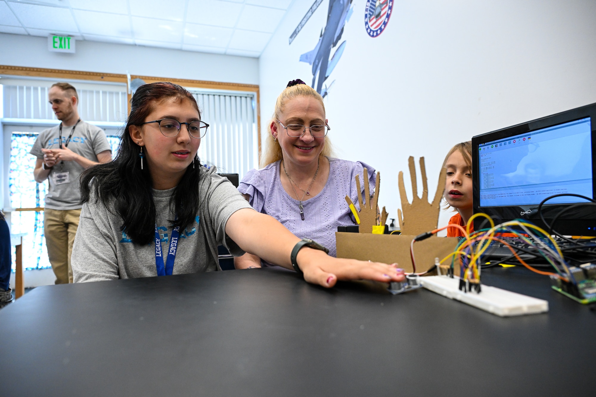 A student demonstrates a STEM project for her family