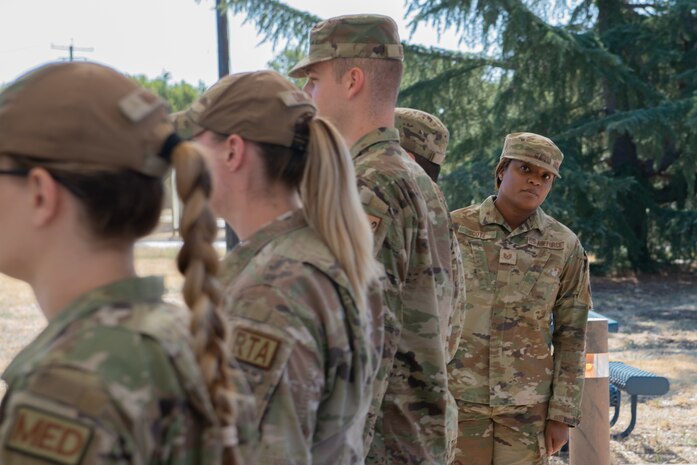 U.S. Air Force Tech. Sgt. Tiffany Scott, 9th  Operations Support Squadron NCO in charge, adjusts the first line of Airmen during open ranks July 10, 2023, at Beale Air Force Base, California.