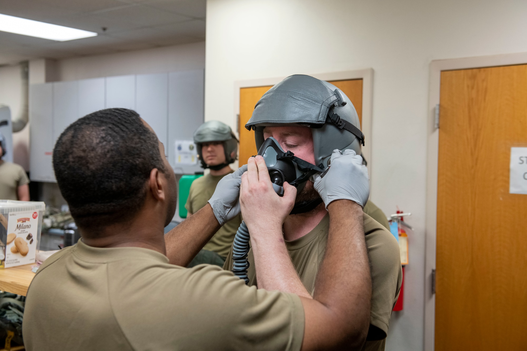 U.S. Air Force Master Sgt. Marques Bones, 9th Force Support Squadron development advisor, aids U.S. Air Force Senior Airman Stewart Grieder, 9th Maintenance Squadron aircrew egress systems, with attaching an oxygen mask to the helmet July 14, 2023, at Beale Air Force Base, California.