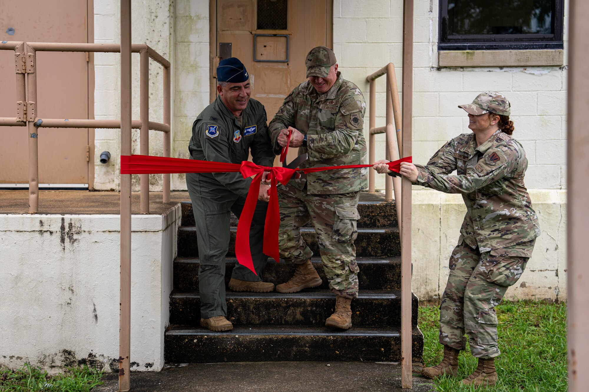 U.S. Air Force Col. Josh Koslov, 350th Spectrum Warfare Wing commander, left, Chief Master Sgt. William Cupp, 350th SWW command chief, center, and Senior Airman Robbi Termentozzi, Program Management Office programs manager, left, cut the ribbon to a newly renovated facility for the 350th SWW Wing Staff Agencies at Eglin Air Force Base, Fla., July 14, 2023. Renovating this facility provided the wing with an opportunity for a new space features a 15-person team room, and a break room with two extra floating workspaces. (Courtesy Photo)
