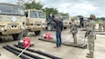 military and civilian personnel working with military fuel trucks