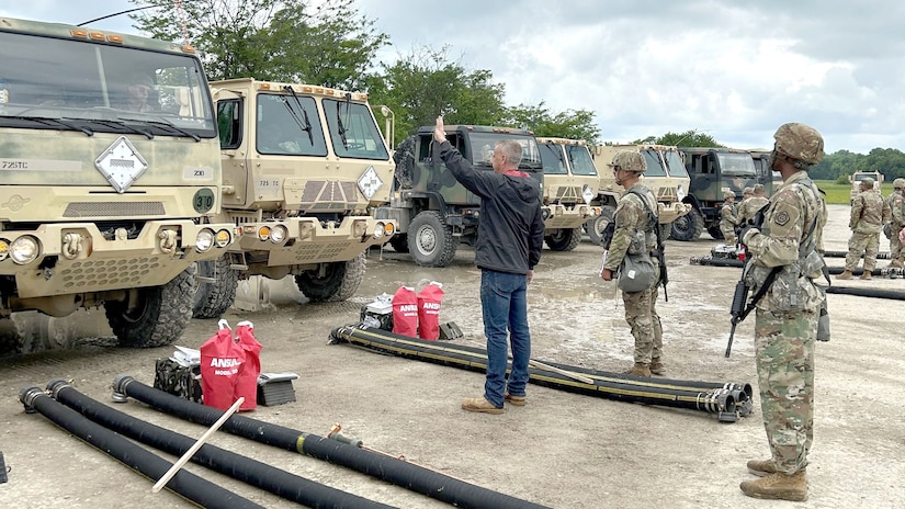 military and civilian personnel working with military fuel trucks