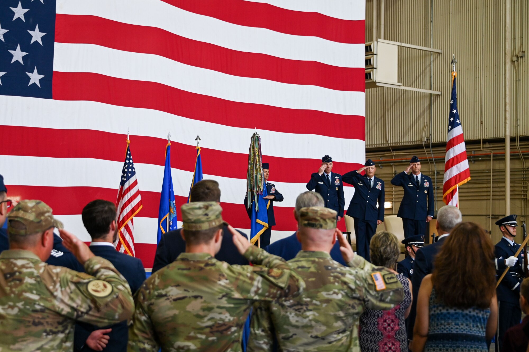 Airmen salute the flag during the playing of the national anthem at the wing change of command at Altus Air Force Base, Oklahoma, July 14, 2023. During the ceremony, Col. Jeffrey Marshall assumed command of the 97th Air Mobiilty Wing. (U.S. Air Force photo by Senior Airman Kayla Christenson)
