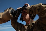 A soldier maintains military equipment.