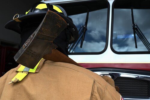 Justin Nava, 17th Civil Engineer Squadron firefighter, carries his gear at the fire station, Goodfellow Air Force Base, Texas, June 30, 2023. A flat-head fire axe is a versatile tool which can be used for smashing windows and doors to create an entry access point or can chop holes in a roof to create ventilation. (U.S. Air Force photo by Airman 1st Class Madison Collier)