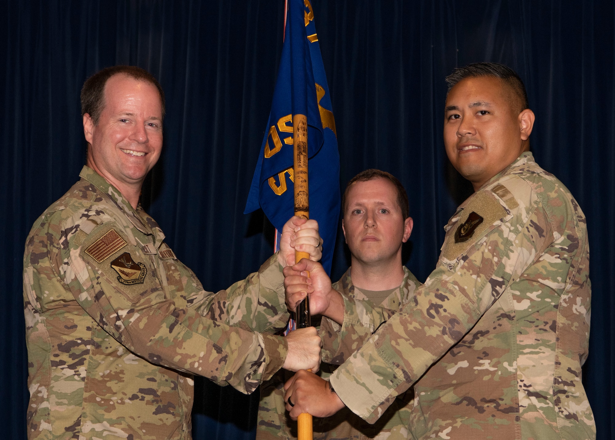 Two military men hold a guidon.