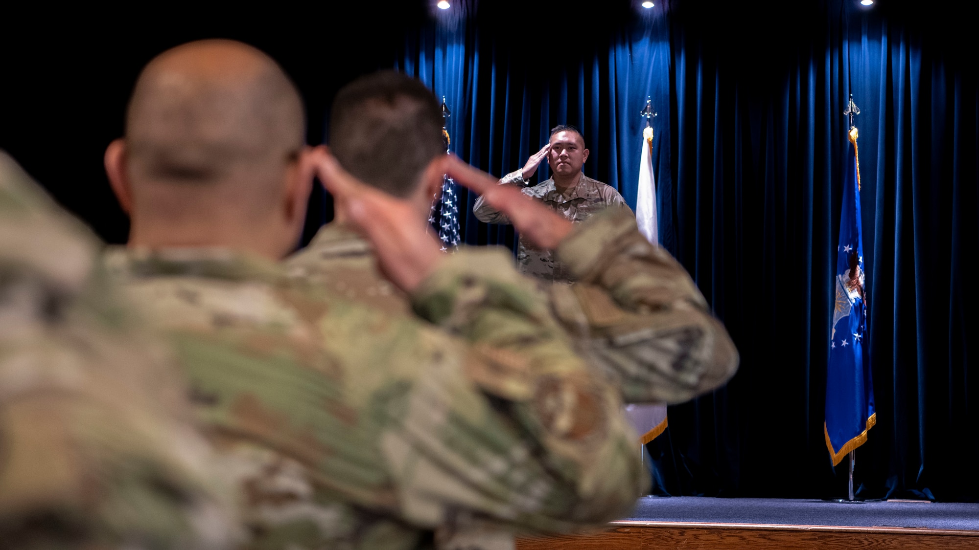 Military man salutes other military members.