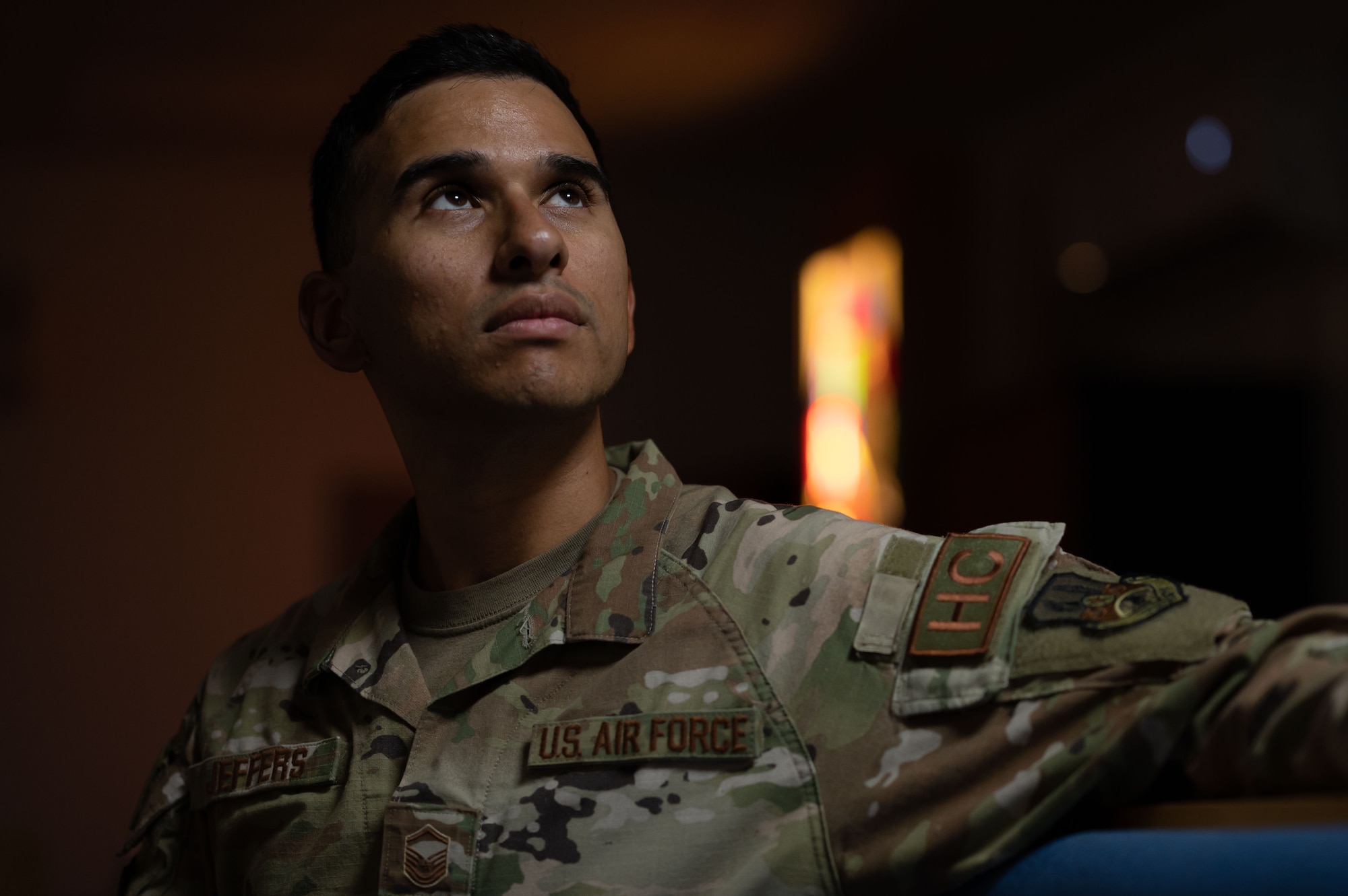 A photo of an Airman sitting in the Chapel.