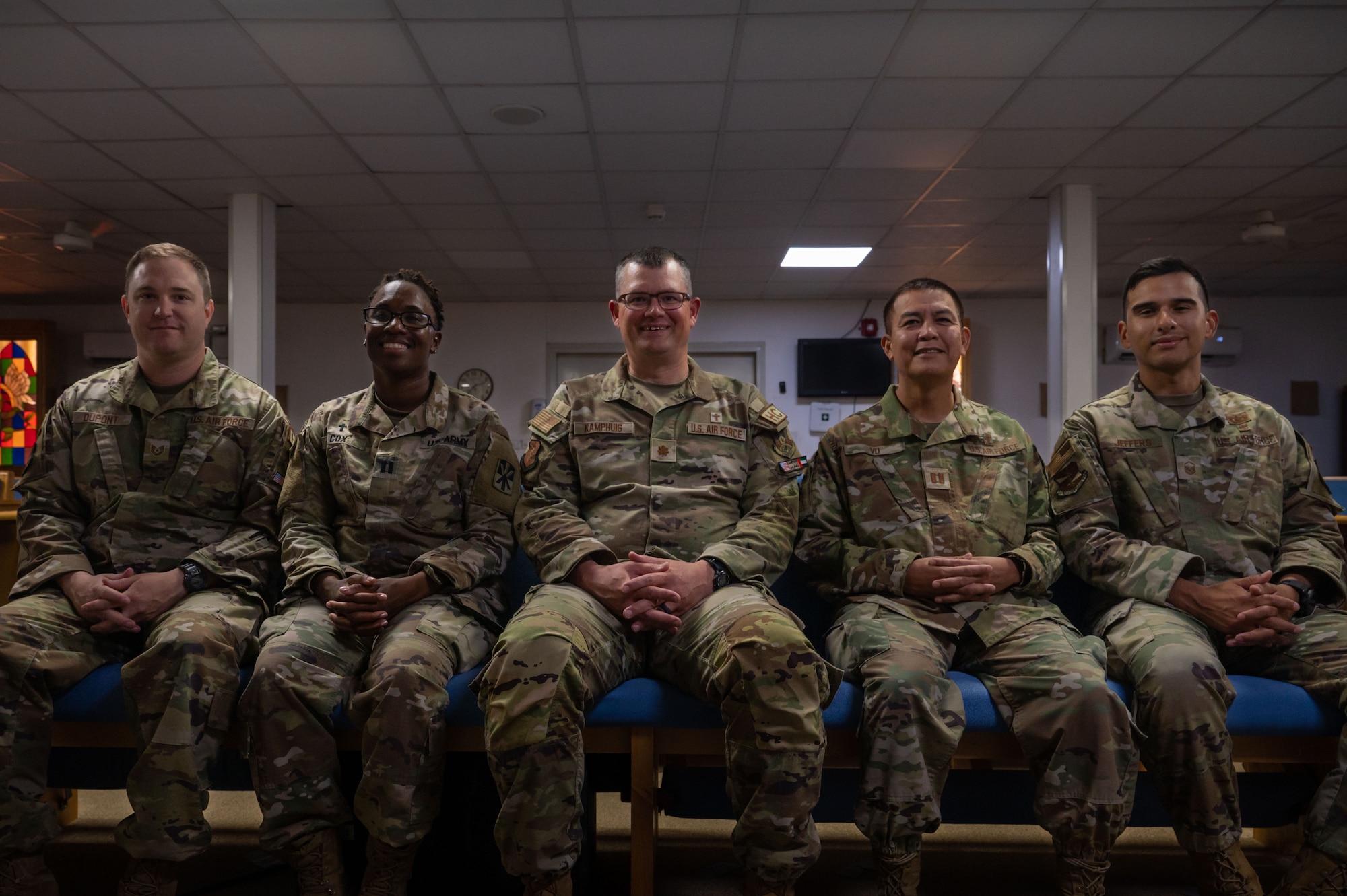 A photo of five Airmen sitting in the Chapel.