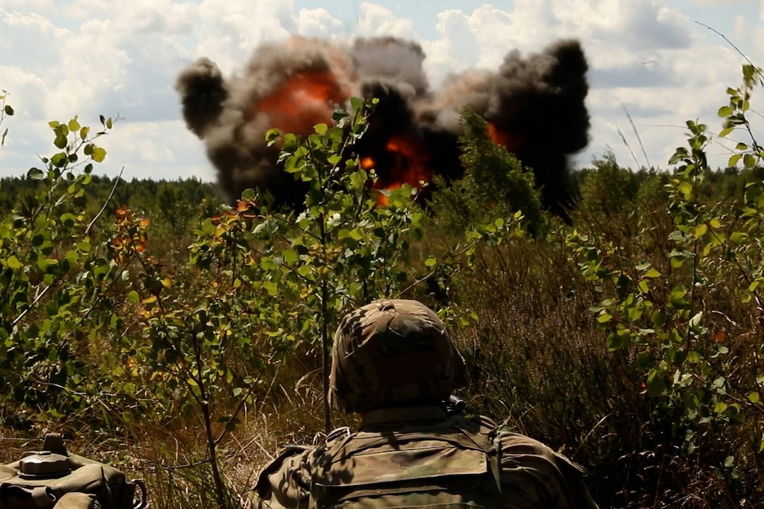 A soldier watches an explosion.