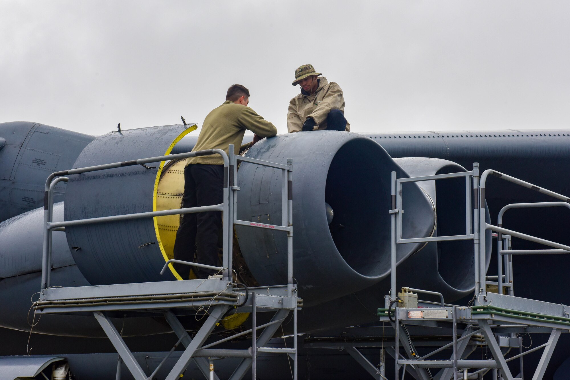 Senior Airman Bryan Caldera and Airman 1st Class Alex Cardenas, 69th Aircraft Maintenance Unit technicians, perform maintenance on a B-52H Stratofortress engine at Joint Base Elmendorf-Richardson, Alaska, July 17, 2023.  The Airmen from the 69th AMU were sent to JBER in support of a bomber Agile Combat Employment exercise. (U.S. Air Force photo by Senior Airman Zachary Wright)