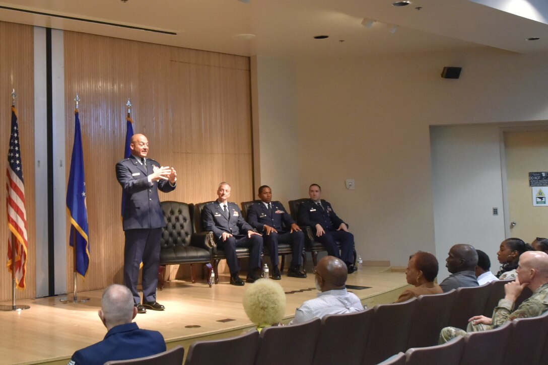 U.S. Air Force Brig. Gen. George Dietrich III addresses the audience as Col. Terry Koester, Maj. W. Frank Larkins, and Maj. Devin Taber listen during the 982d MXS inactivation and 82d TRSS activation ceremony.