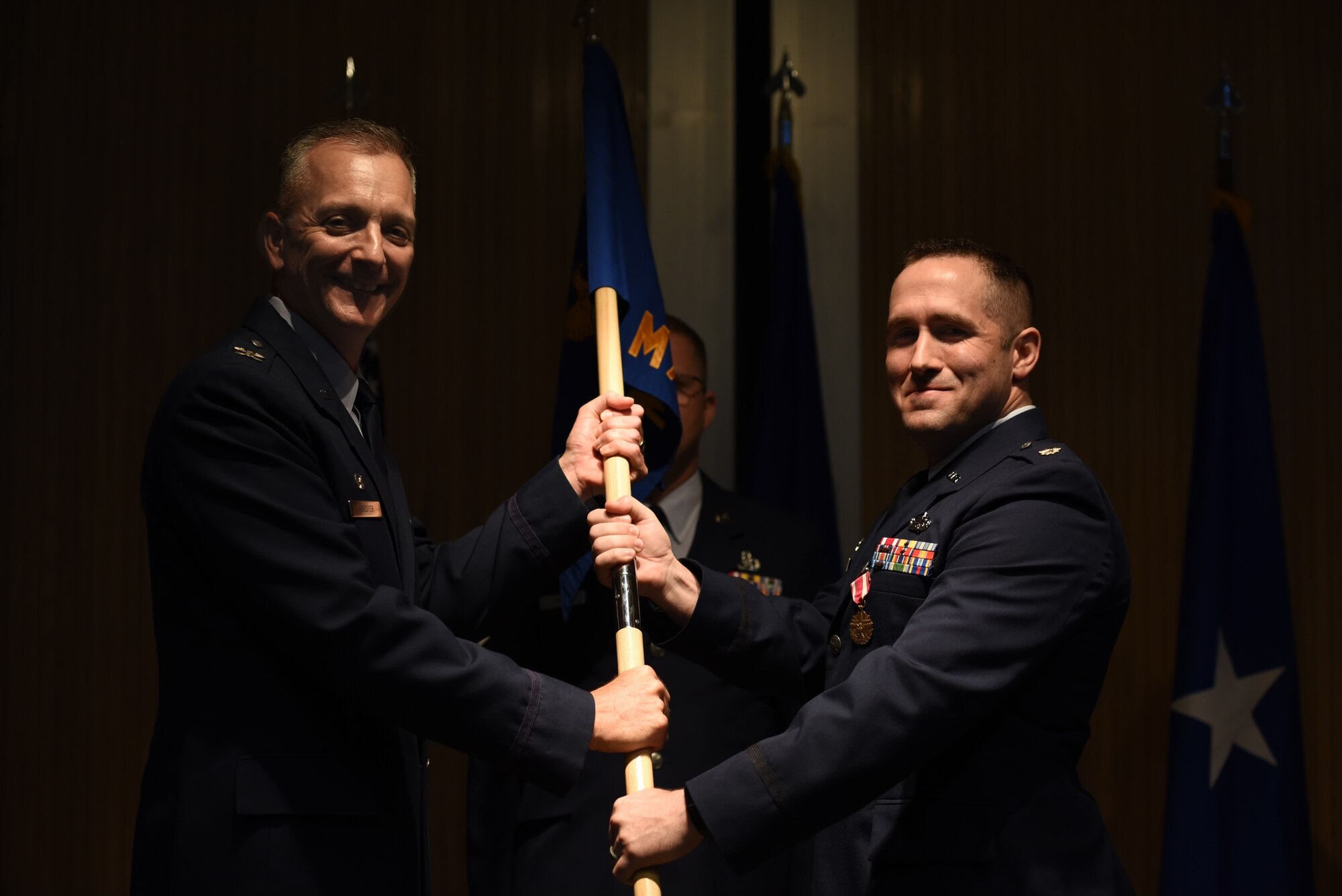 U.S. Air Force Col. Terry Koester accepts the 982d MXS squadron guidon from Air Force Maj. Devin Taber as he relinquishes command.