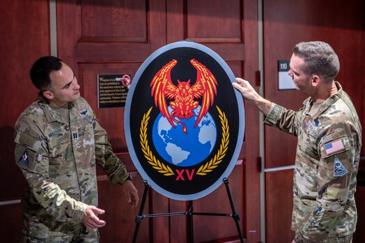  Two men in uniform unveil an emblem