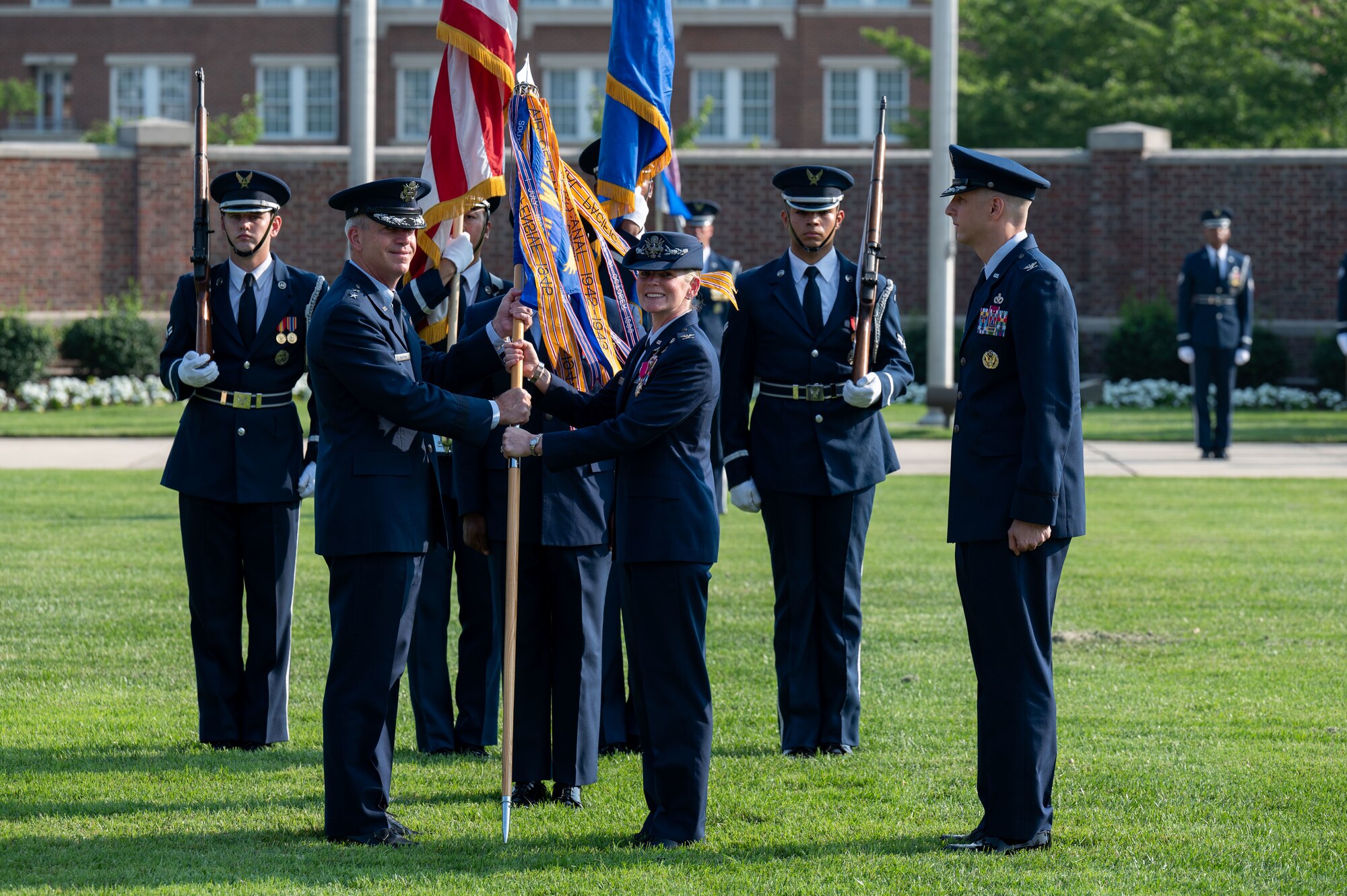 U.S. Air Force Maj. Gen. Joel D. Jackson, left, Air Force District of Washington and 320th Air Expeditionary Wing commander, receives the 11th Wing guidon from Col. Catherine “Cat” Logan, outgoing commander of Joint Base Anacostia-Bolling and the 11th Wing, during a change of command ceremony at JBAB, Washington, D.C., July 18, 2023. Logan became the first female commander of JBAB and the 11th Wing in 2021. Under Logan’s command, JBAB reached Full Operating Capability, completed more than $58 million in base infrastructure projects to include quality of life improvements, executed two Air Force 75th Anniversary Tattoo celebrations and deployed personnel for the first time since the lead service transfer in 2020. (U.S. Air Force photo by Kristen Wong)