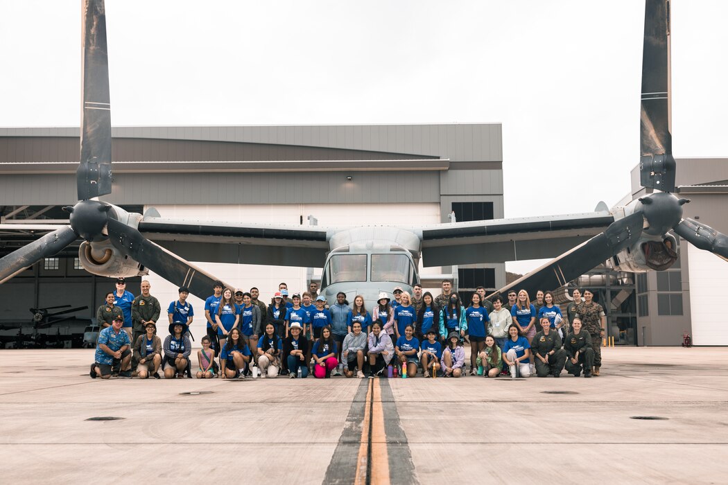 U.S. Marines with Marine Medium Tiltrotor Squadron 268 (VMM-268), Marine Aircraft Group 24, 1st Marine Aircraft Wing, and Pearl Harbor Aviation Museum "Flight School" summer camp students pose for a group photo at Marine Corps Air Station Kaneohe Bay, Marine Corps Base Hawaii, July 11, 2023. VMM-268 partnered with the summer camp to introduce middle school students to the aviation career field and enhance community relations. (U.S. Marine Corps photo by Cpl. Christian Tofteroo)