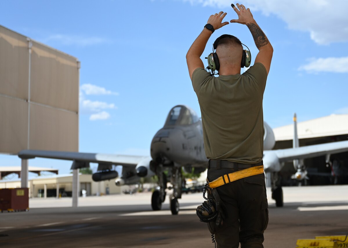 U.S. Air Force Senior Airman Thomas Snyder, 357th Fighter Generation Squadron crew chief, marshalls in an A-10C Thunderbolt II aircraft at Davis-Monthan Air Force Base, Ariz. July 17, 2023. The 357th FGS executes all aspects of on-aircraft maintenance so the A-10C student pilots can continue to train for combat . (U.S. Air Force photo by Staff Sgt. Abbey Rieves)
