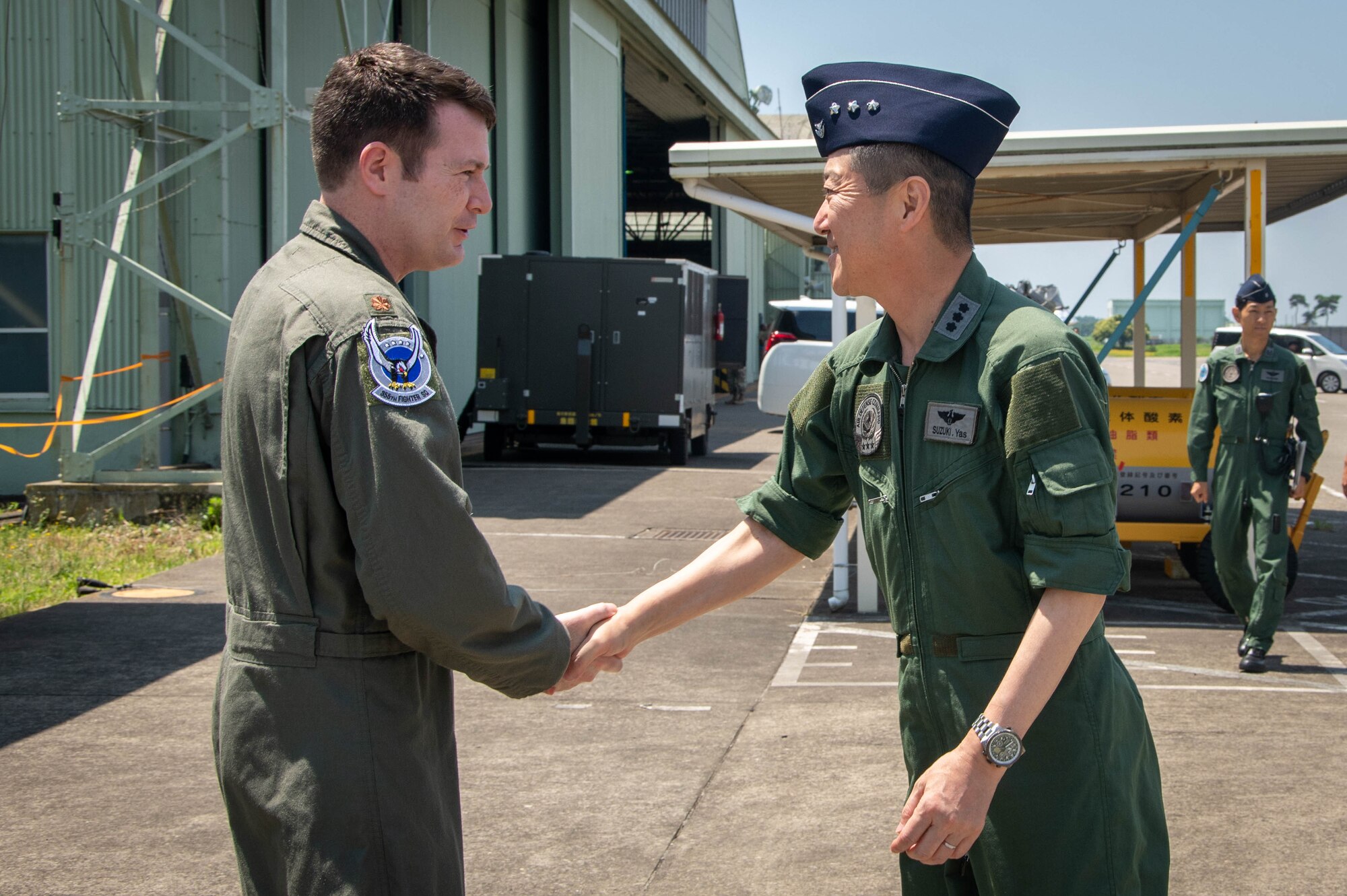 An Airman greets a JASDF member.