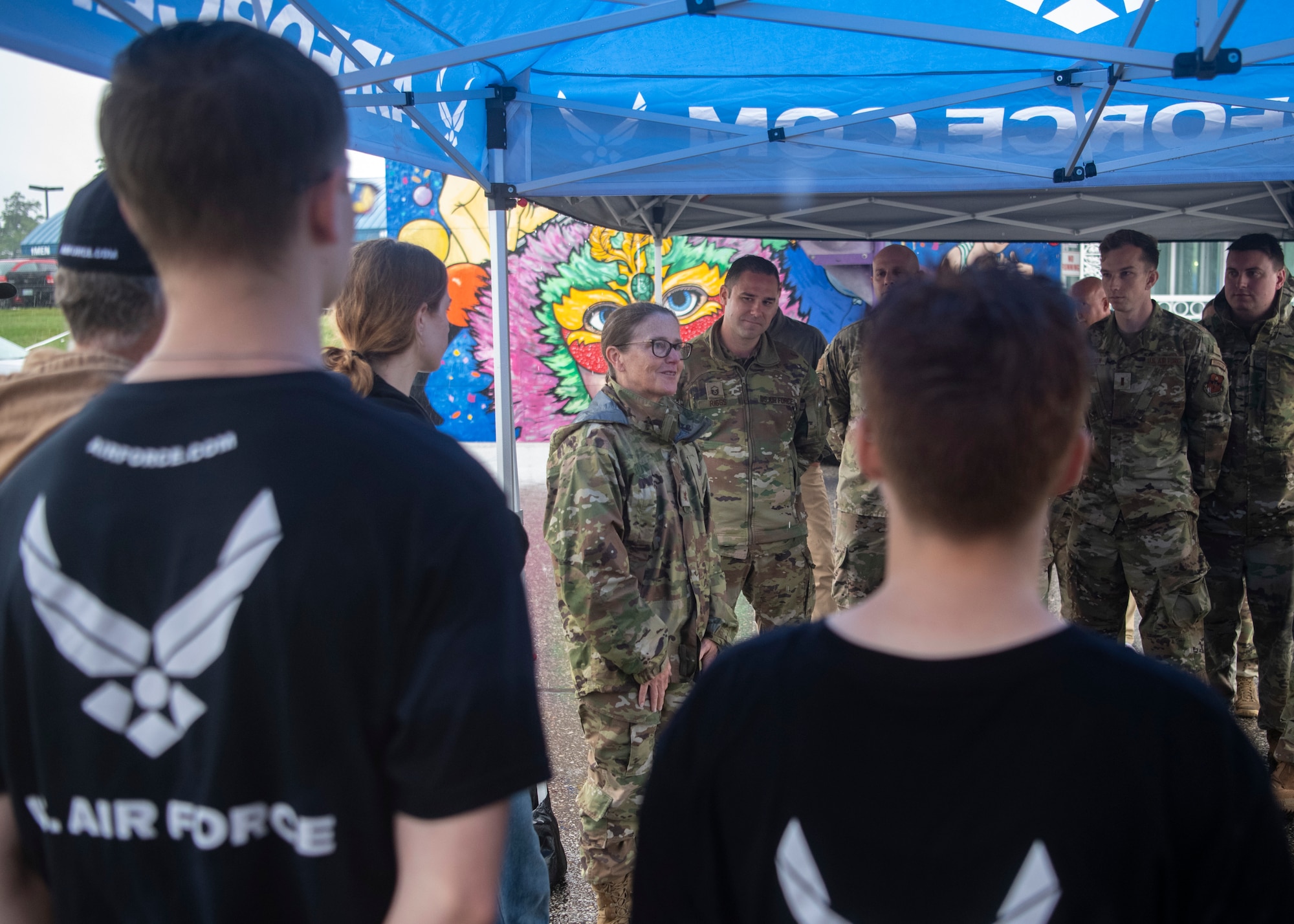 Airmen and recruits stand under a tent at the New Hampshire Motor Speedway