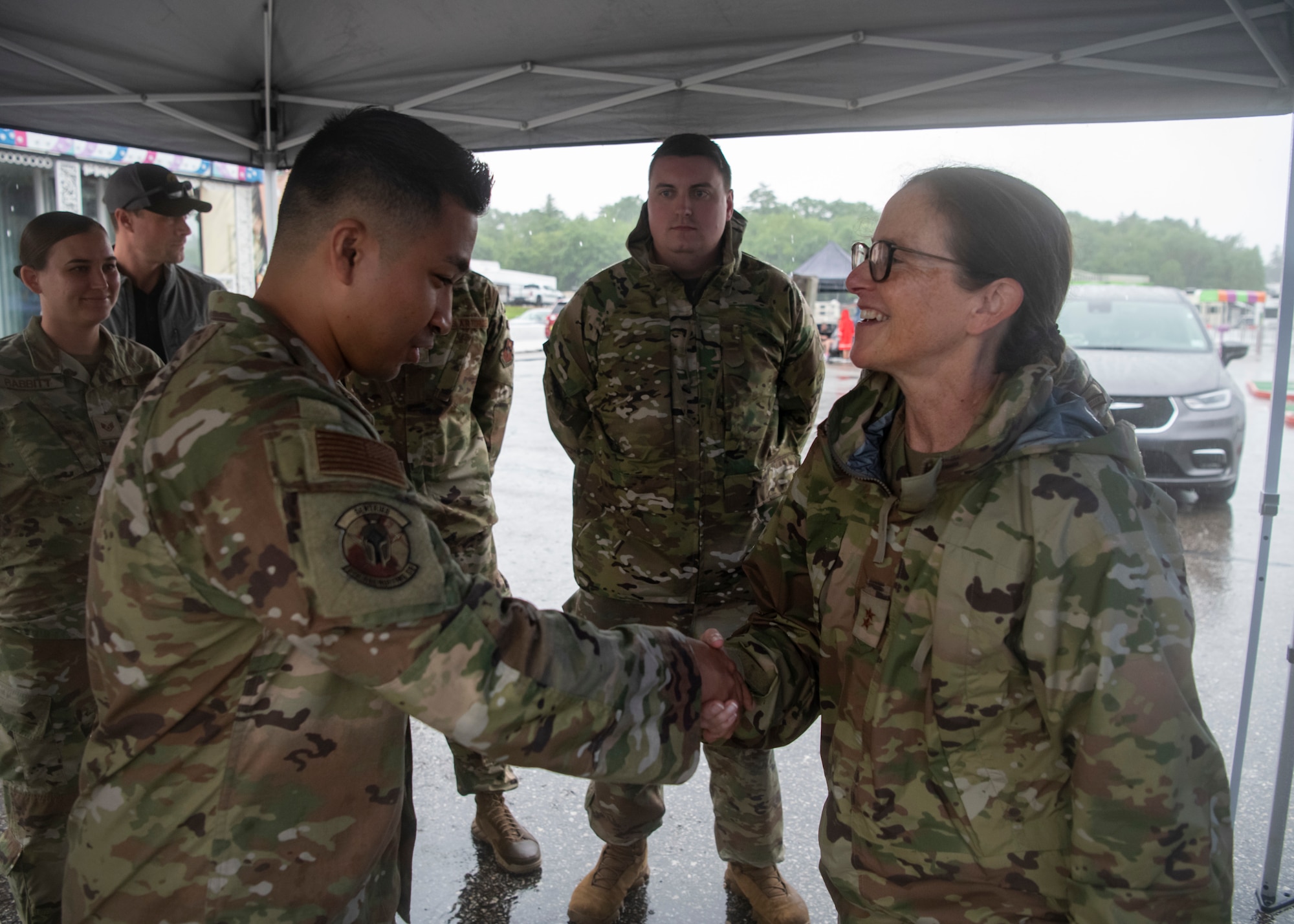 Two Airmen shake hands under a tent at New Hampshire Motor Speedway