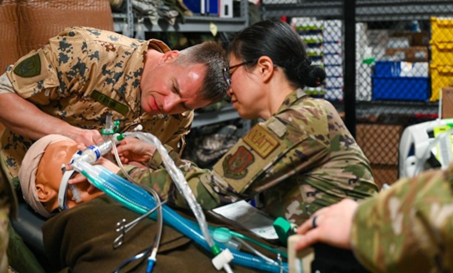U.S. Air Force Maj. Alisha Young, center, 433rd Medical Group Critical Care Air Transport Team physician, demonstrates how to adjust respiratory control equipment to 1st Lt. Martti Eerma, left, a reservist from the Estonia Defense Force at Joint Base San Antonio - Lackland, Texas, June 4, 2023. The exchange program encourages reservists to exchange forces to improve NATO interoperability through an official agreement with the Estonian Embassy in Washington, D.C., on Feb.10, 2015. (U.S. Air Force photo by Staff Sgt. Adriana Barrientos)