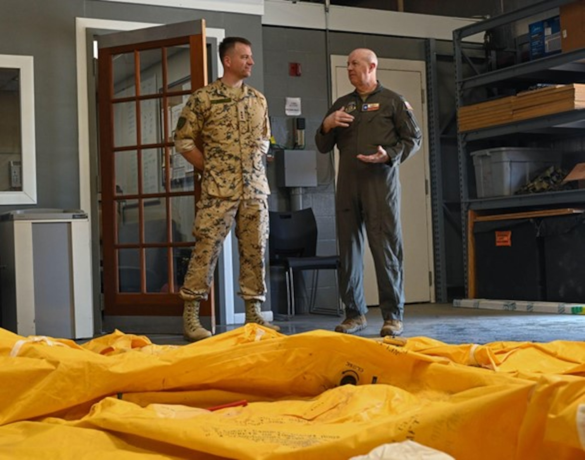 1st Lt. Martti Eerma, left, a reservist from the Estonia Defense Force, listens to U.S. Air Force Col. James Miller, right, 433rd Operations Group commander, as he talks about training priorities for survival, evasion, resistance, and escape training in front of a 25-man survival raft at Joint Base San Antonio- Lackland, Texas, May 29, 2023. The exchange program encouraged reservists to exchange forces to improve NATO interoperability through an official agreement with the Estonian Embassy in Washington, D.C., on Feb.10, 2015. (U.S. Air Force photo by Staff Sgt. Adriana Barrientos)