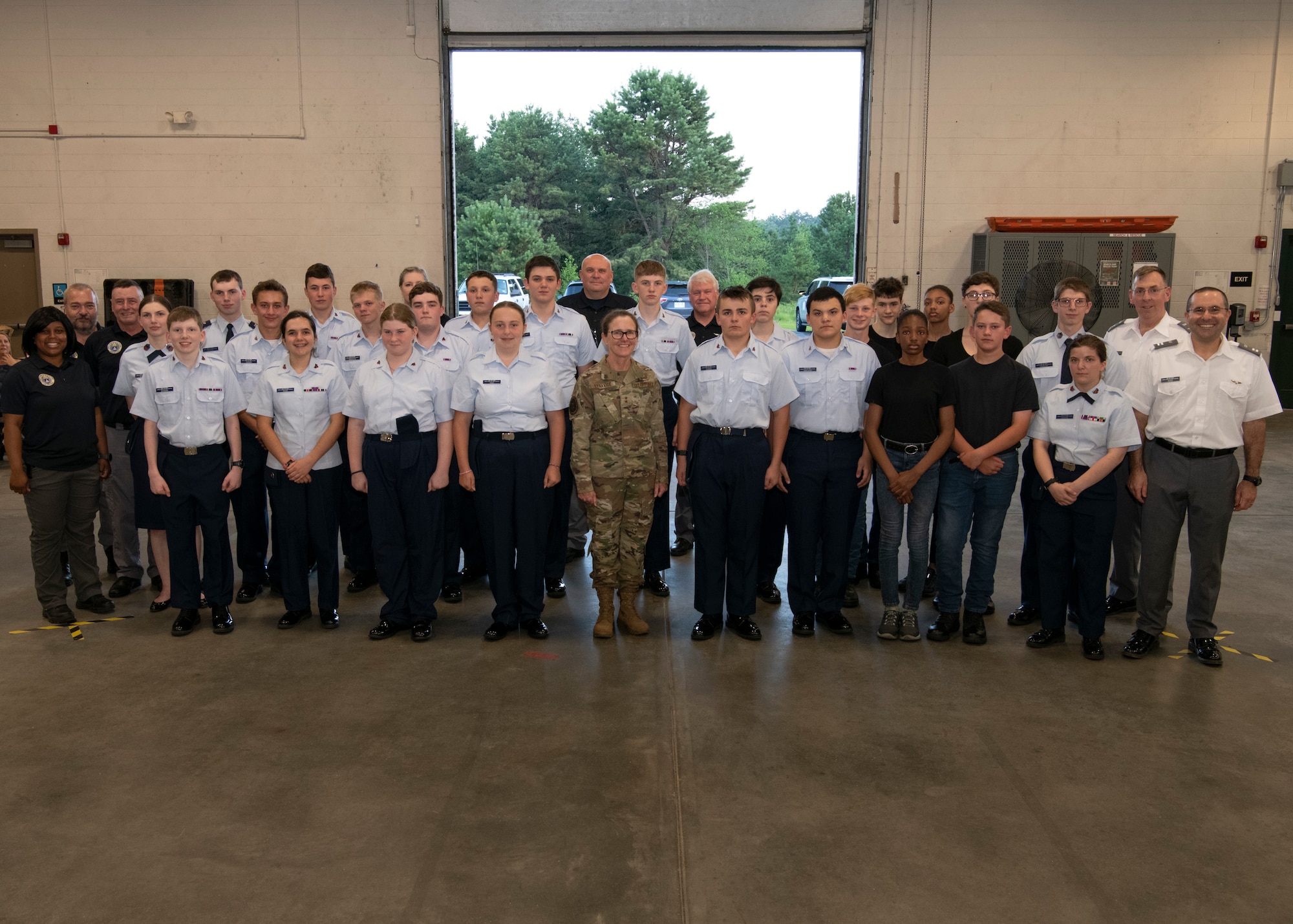 Civil Air Patrol cadets pose with senior leadership in a hanger