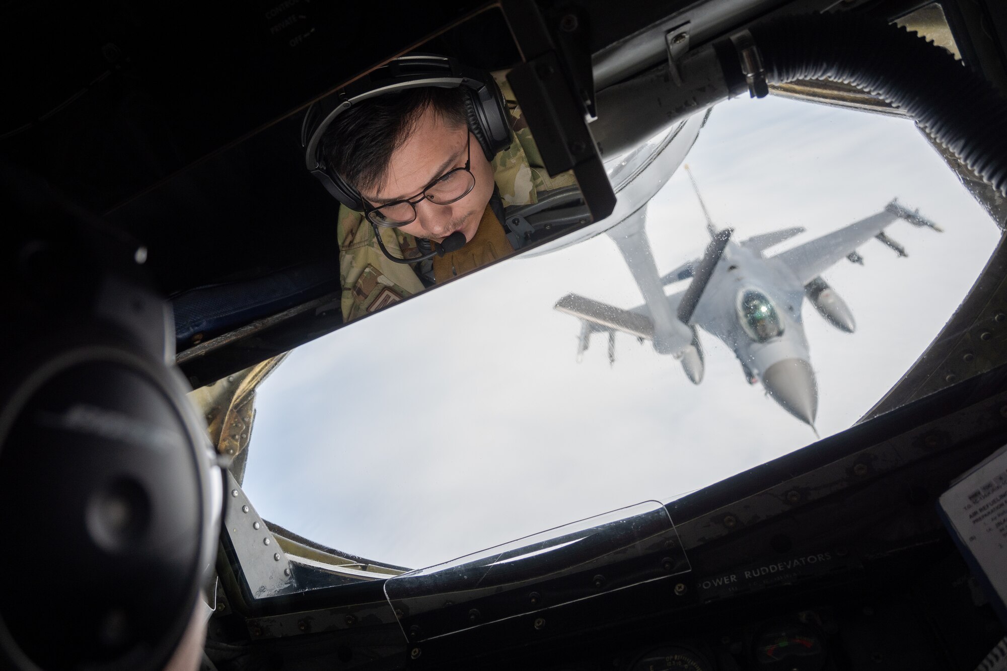 Senior Airman Christian Lawhorn prepares to refuel a U.S. Air Force F-16 Fighting Falcon over the Pacific Ocean.