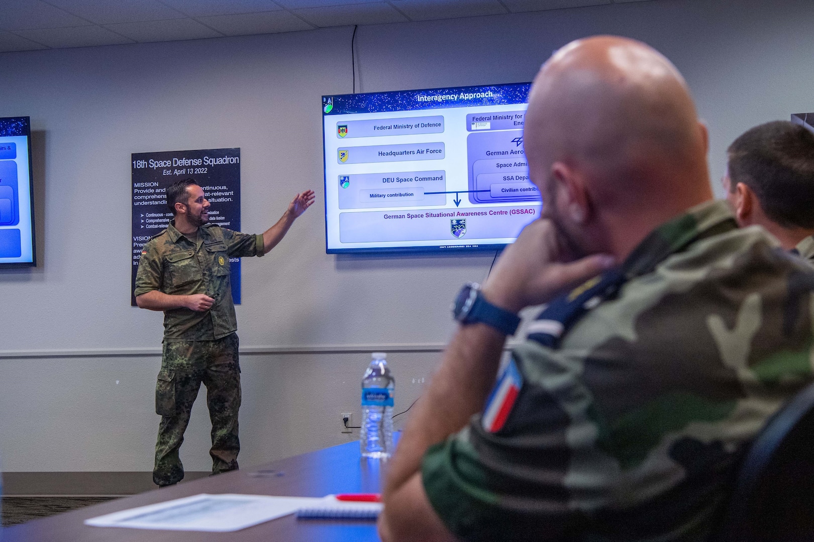 Germany Air Force Capt. Dennis Hall, German Space Situational Awareness Centre space operator, briefs members of the 18th Space Defense Squadron and the Operational Center for Military Surveillance of Space Objects during the first day of the Operator Exchange program at Vandenberg Space Force Base, Calif., July 10, 2023. The GSSAC is a civil-military facility that provides space situational awareness for the German government. It uses national and commercial capabilities to create a situational view of space. (U.S. Space Force photo by Julian Labit)