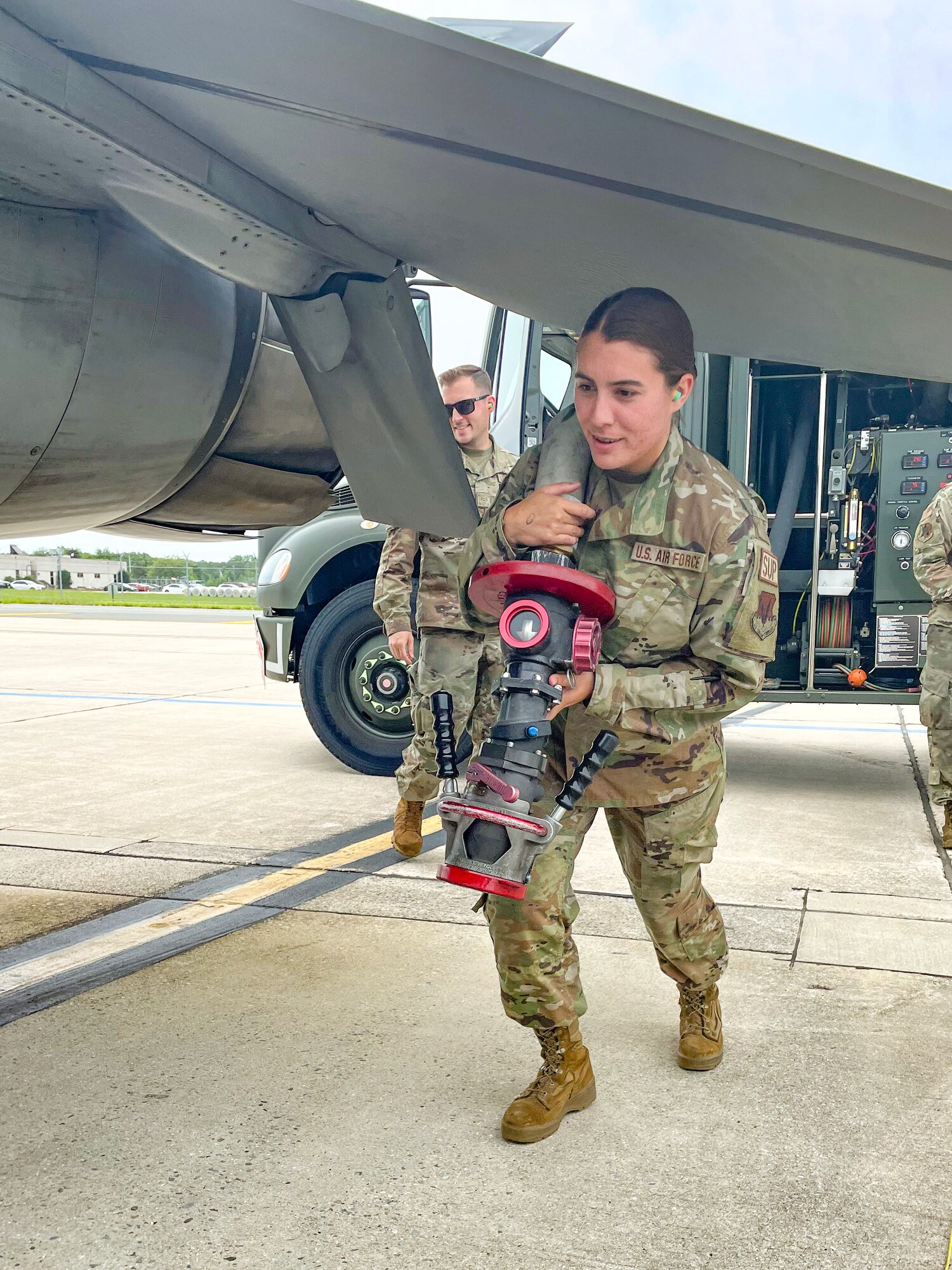 A photo of Staff Sgt. Kaitlin Delucca extending an R-11 Refueler hose for aircraft servicing operations.