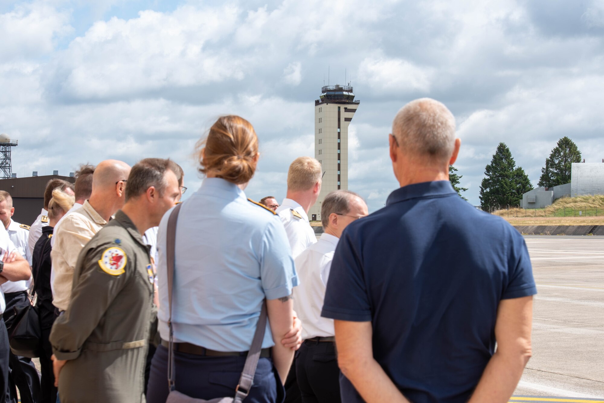 People look at an air traffic control tower.