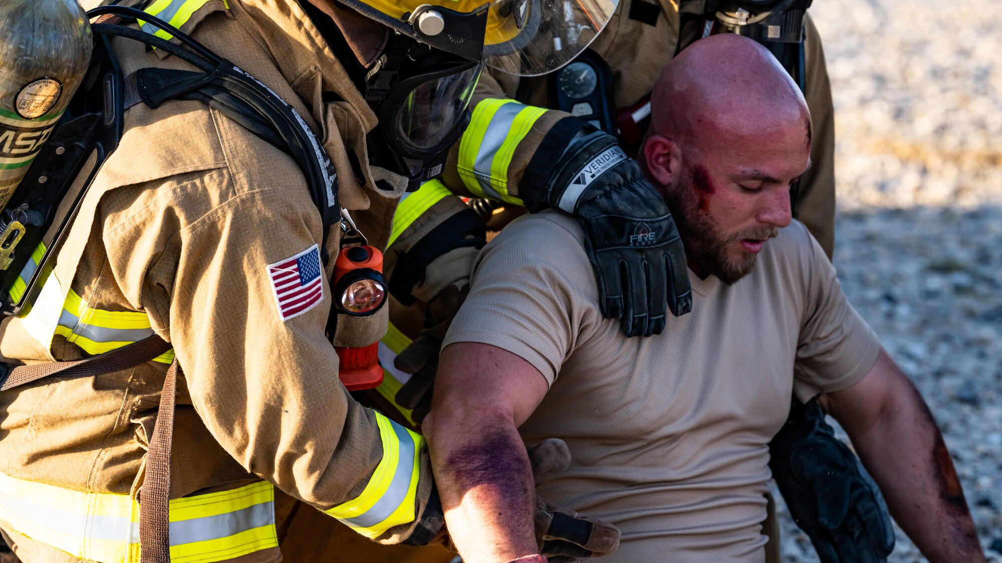 U.S. Air Force fire protection Airmen from the 386th Expeditionary Civil Engineer Squadron rescue a victim from a simulated aircraft accident during a medical response exercise at Ali Al Salem Air Base, Kuwait, July 17, 2023. This exercise tested the emergency response systems of U.S. and coalition forces, which allowed for a better understanding of how they can communicate and operate together in the event of a real-world emergency. (U.S. Air Force photo by Staff Sgt. Kevin Long)