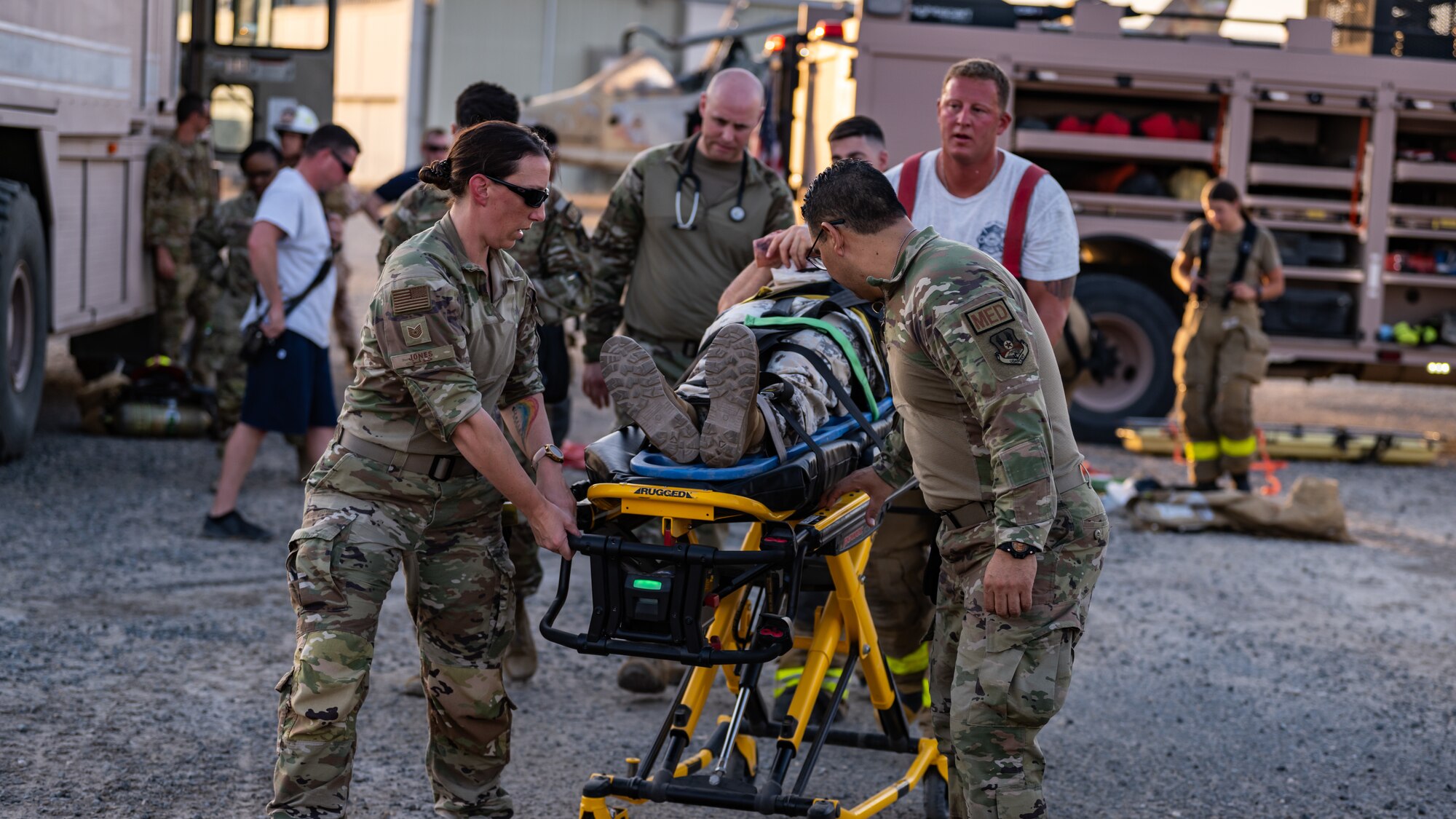 U.S. Air Force Airmen from the 386th Expeditionary Medical Squadron transfer a victim from a simulated aircraft crash to an ambulance during a medical response exercise at Ali Al Salem Air Base, Kuwait, July 17, 2023. This exercise tested the emergency response systems of U.S. and coalition forces, which allowed for a better understanding of how they can communicate and operate together in the event of a real-world emergency. (U.S. Air Force photo by Staff Sgt. Kevin Long)